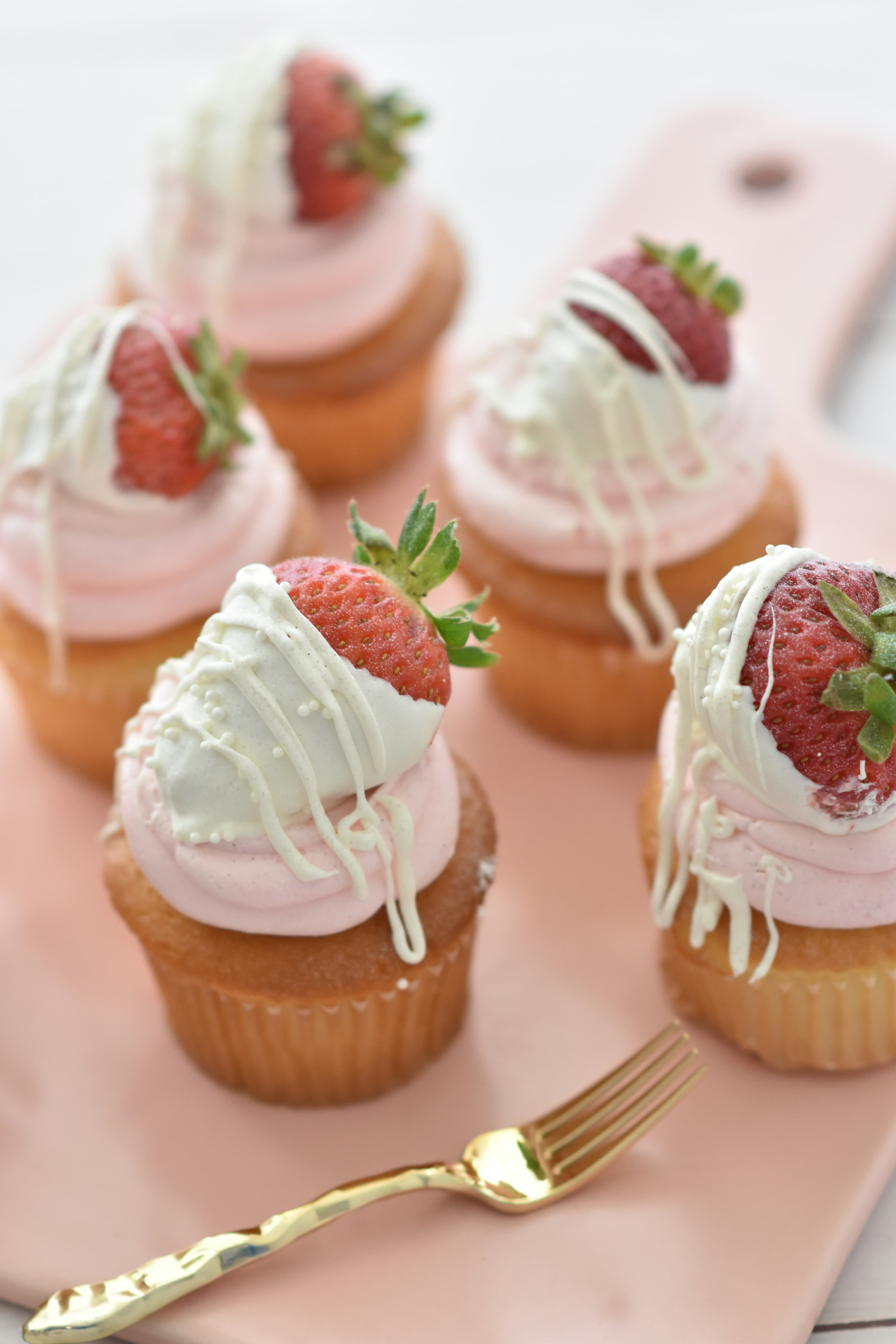 Cupcakes with cream frosting and fresh strawberries